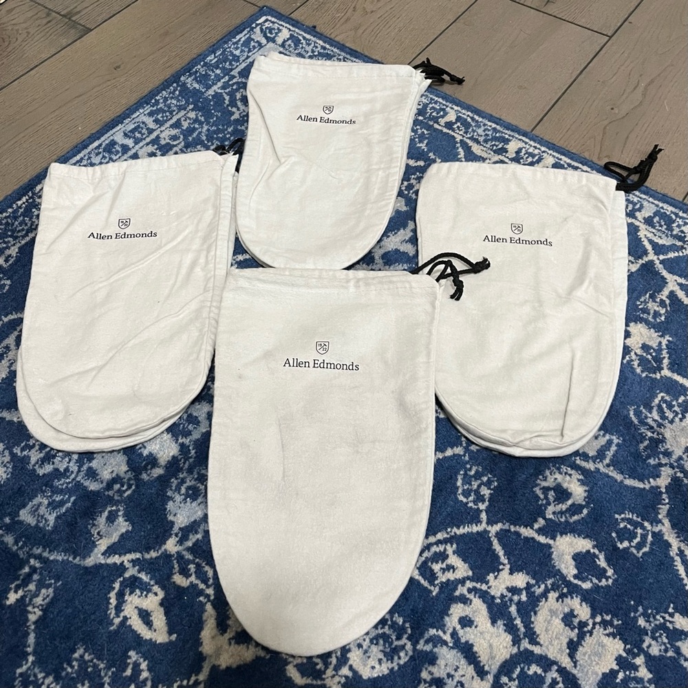 Four pairs of white Allen Edmonds shoe bags.
